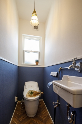 ツートンの壁紙が可愛らしいトイレ。配管が見えるスタイルで個性があって素敵です。