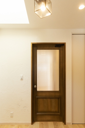 玄関から見えるリビングドアは、落ち着いたデザインと色