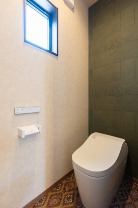モスグリーンのクロスとエキゾチックなクッションフロアのトイレ